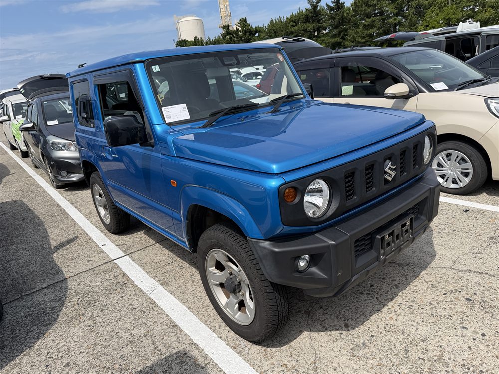 Синий Suzuki Jimny на автомобильной площадке